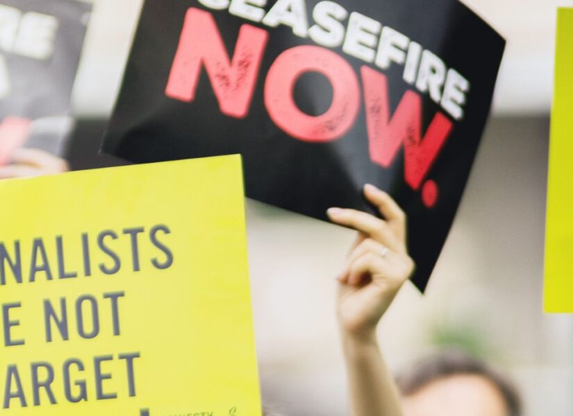 cartelli con su scritto: cessate il fuoco, i giornalisti non sono un bersaglio e basta armare israele (in inglese).