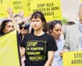 Attivisti con cartelli "stop al genocidio israeliano su Gaza", "stop alla vendita di armi a Israele".