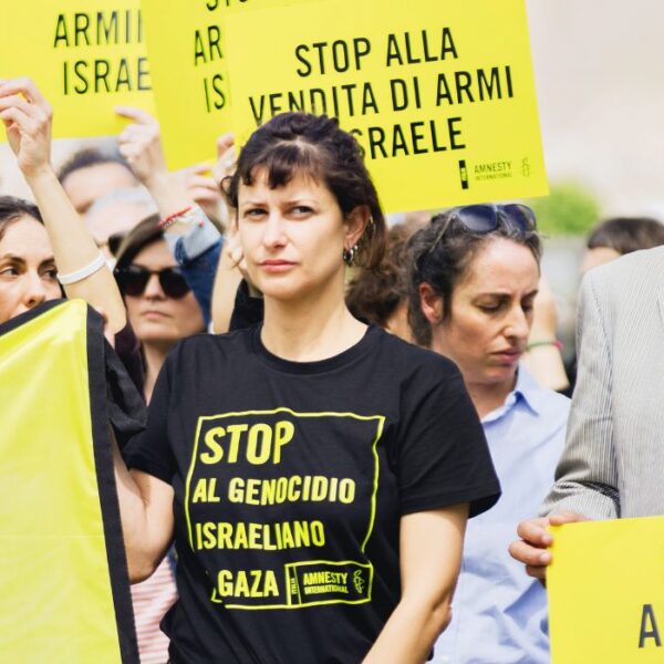 Attivisti con cartelli "stop al genocidio israeliano su Gaza", "stop alla vendita di armi a Israele".
