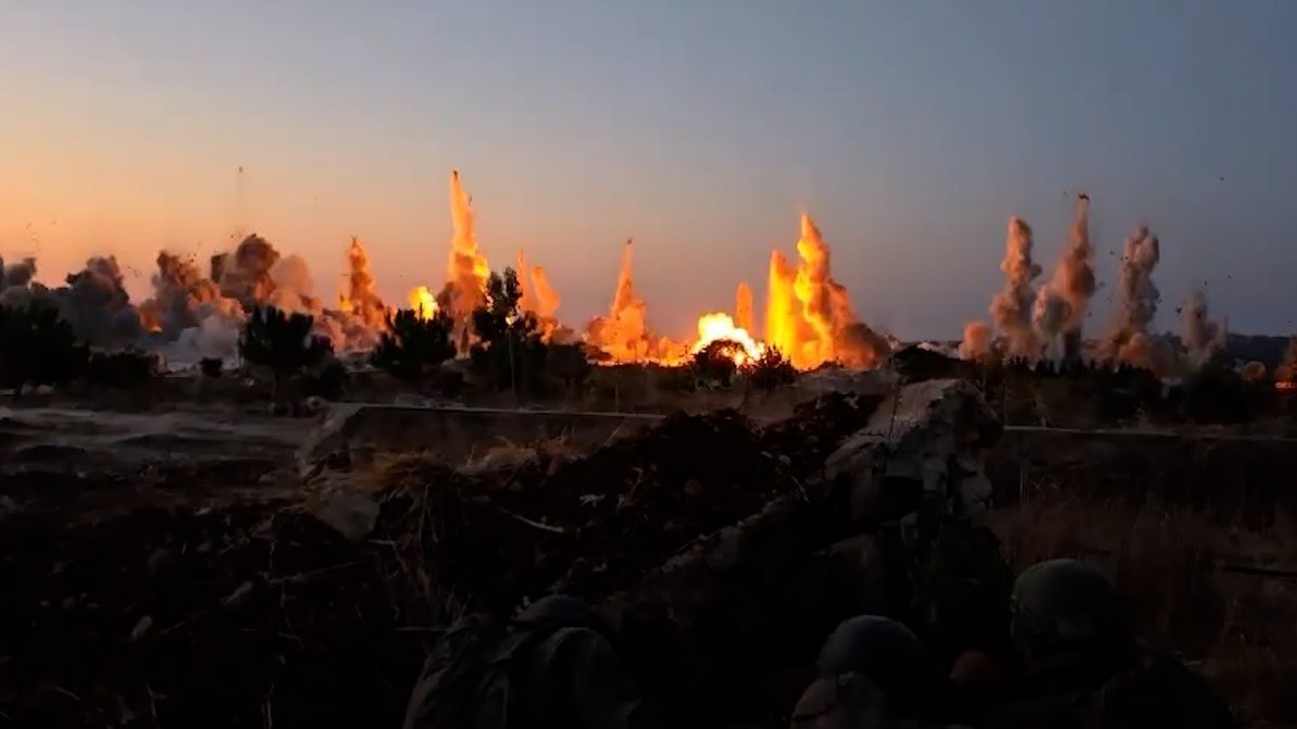 Un fotogramma di un video pubblicato sui social media mostra, in basso a destra, soldati israeliani mentre assistono alla distruzione, tramite esplosivi collocati manualmente, di una vasta area di Dhayra, nel sud del Libano. 