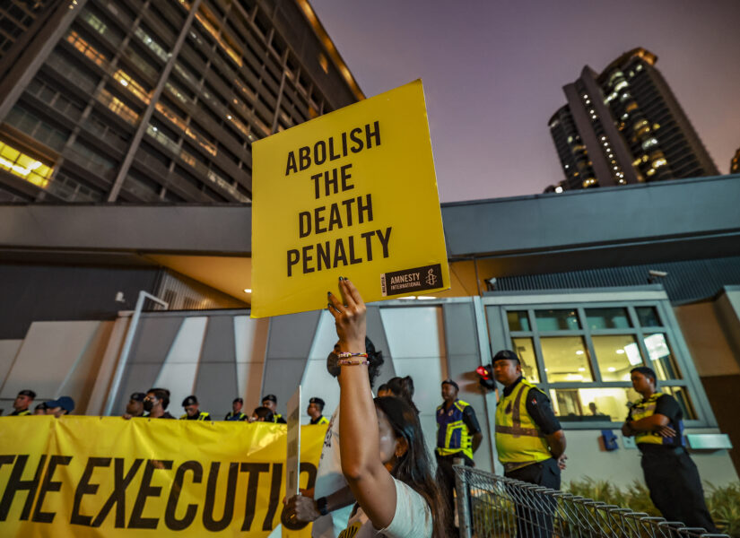 Attivisti di Amnesty International con cartellone in mano "Abolire la pena di morte".