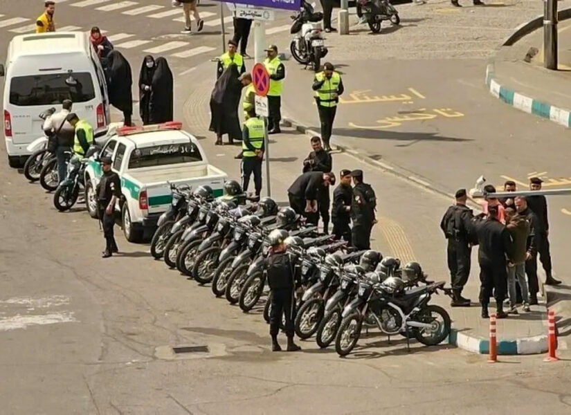 Forze di sicurezza iraniane dispiegate con macchine, moto e van per attuare posti di blocco.