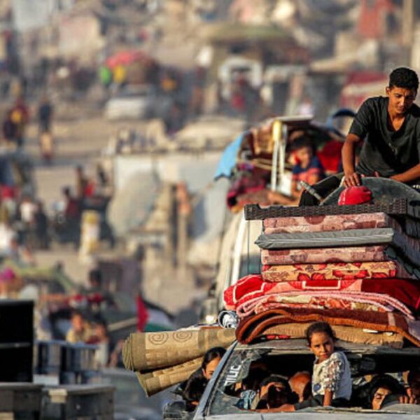 Una ragazza spunta da un parabrezza rotto nella parte anteriore di un veicolo che trasporta persone e i loro beni durante l'evacuazione verso sud da Gaza City il 2 settembre 2025.