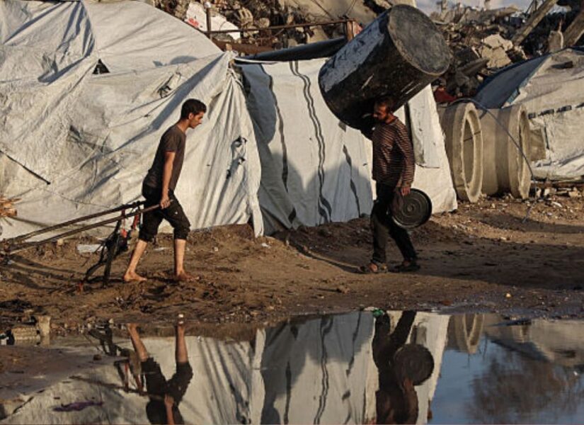 Un palestinese sfollato tira un carro dopo una forte pioggia nella città di Jabalia, nel nord della Striscia di Gaza, il 25 novembre 2025.