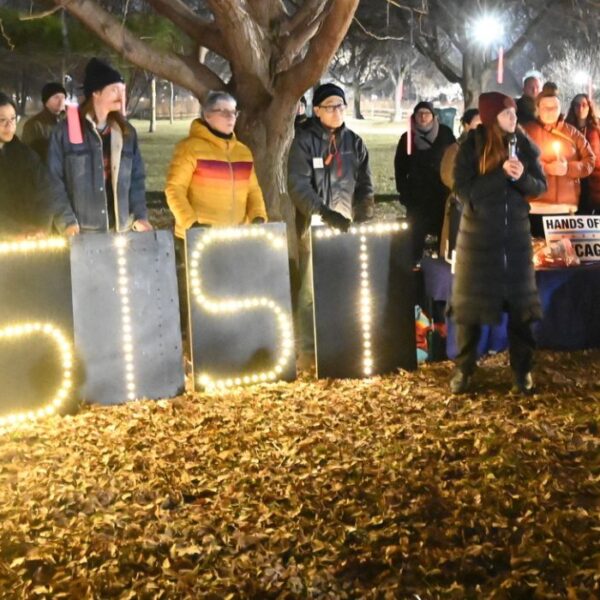 veglia a chicago contro le operazioni dell'ICE, si legge una scritta luminosa "Resist ICE"