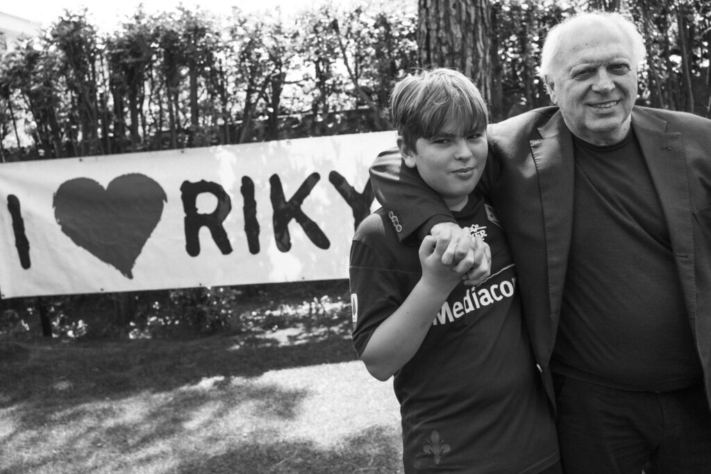 Il padre e il figlio di Riccardo Magherini davanti allo striscione "I love Riky"