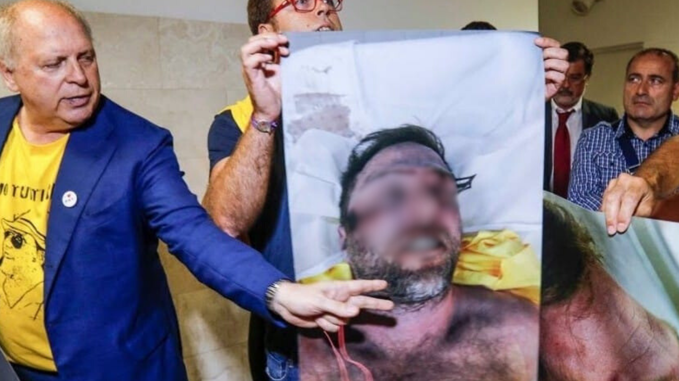 Persone tengono in mano una gigantografia con il volto tumefatto di Riccardo Magherini