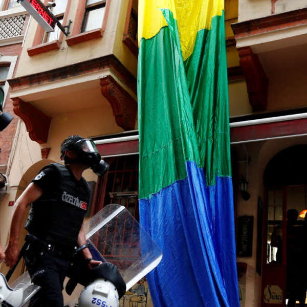 Turchia repressione della comunità lgbtqia+. Nell'immagine: forze di polizia sfilano davanti a una bandiera lgbtqia+
