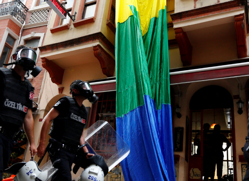 Turchia repressione della comunità lgbtqia+. Nell'immagine: forze di polizia sfilano davanti a una bandiera lgbtqia+