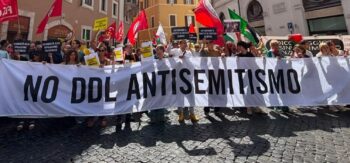 Striscione "No ddl antisemitismo" bianco con scritta nera.
