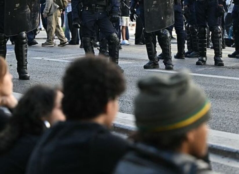 studenti che manifestano in francia. sullo sfondo scarponi della polizia.